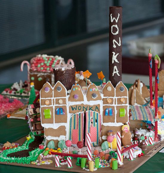 a gingerbread house decorated with candy and candies on a green tablecloth covered table