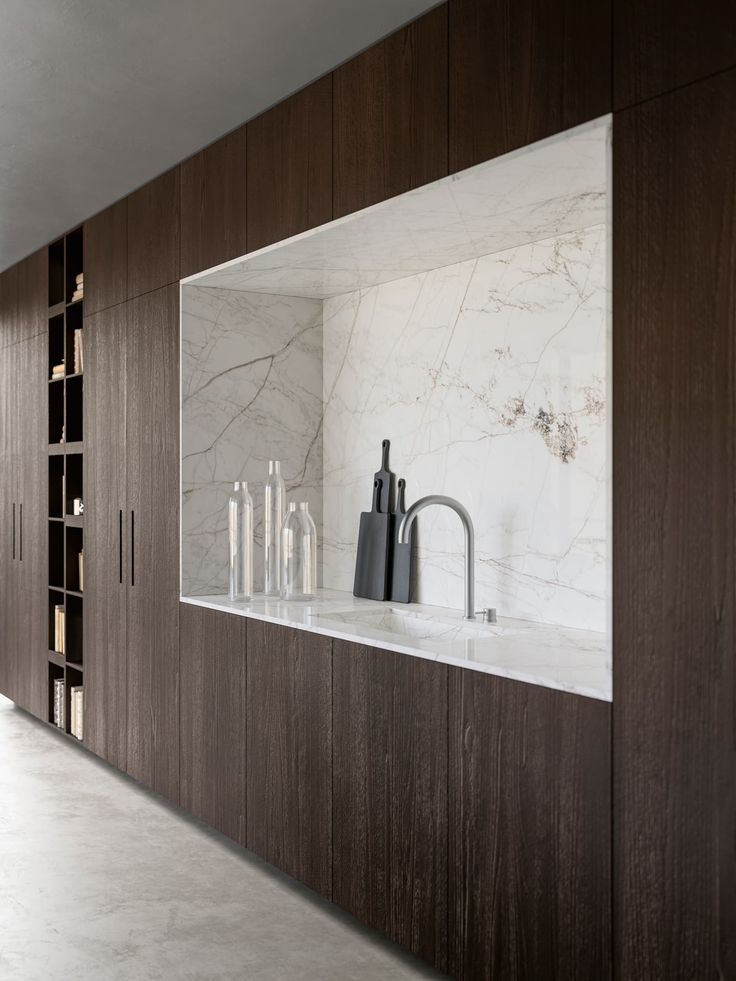 a kitchen with marble counter tops and dark wood cabinetry, along with candle holders