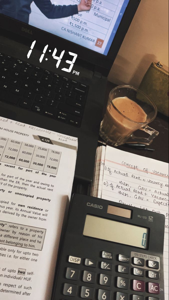 an open laptop computer sitting on top of a desk next to a calculator