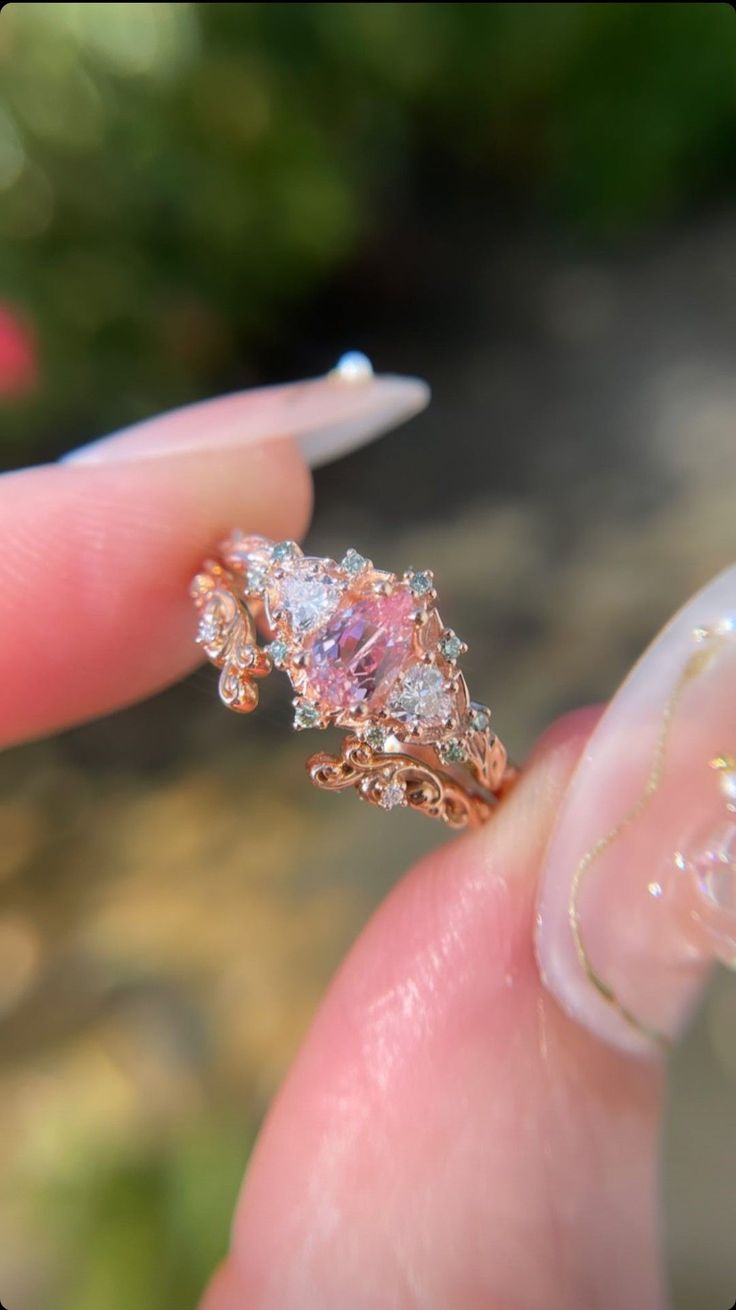 a close up of a person's hand holding a ring