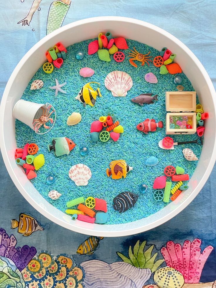 a bowl filled with lots of different types of sea life on top of a blue table cloth