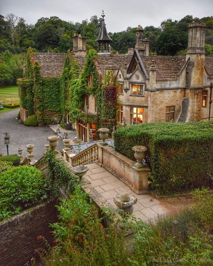 an old house with ivy growing on it's walls and stairs leading up to the front door