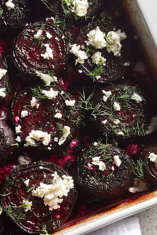 roasted beets with goat cheese and herbs in a baking dish