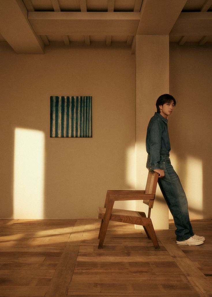 a man standing on top of a wooden chair