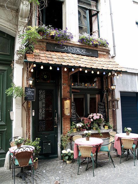 the outside of a restaurant with tables and chairs