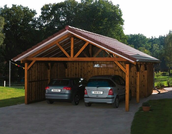 two cars parked in front of a wooden garage