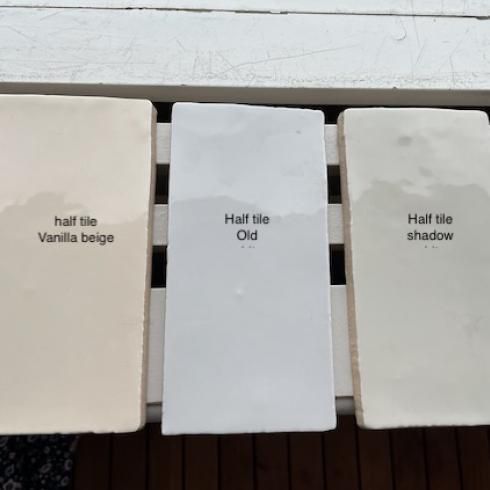 three different shades of white paint sitting on top of a wooden bench