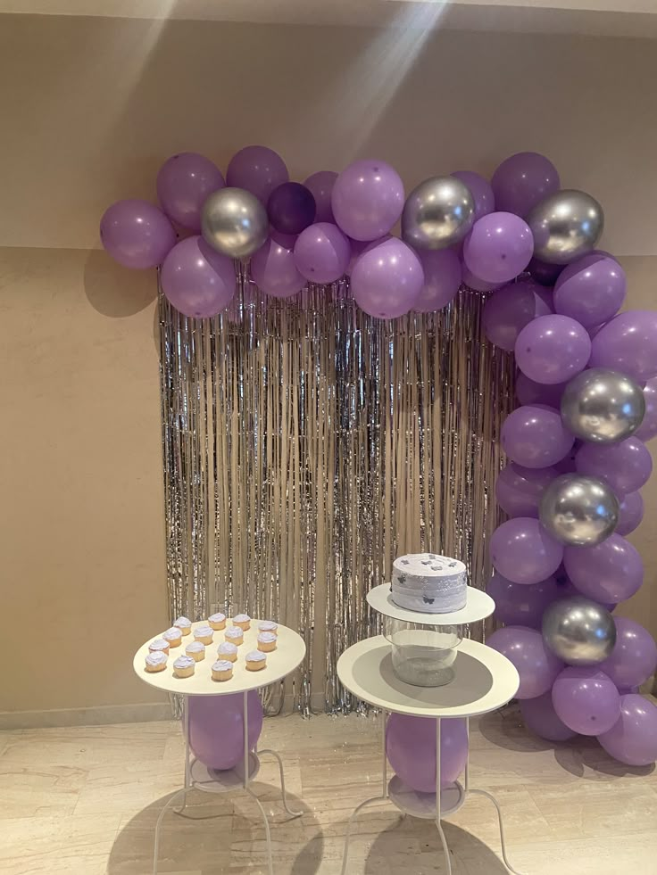 a table with cupcakes and balloons on it