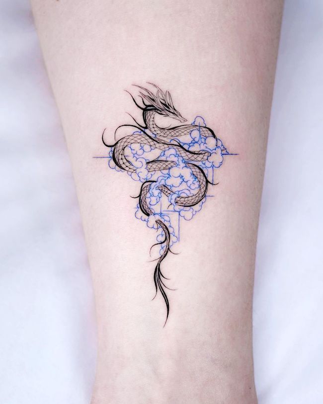 a woman's foot with a dragon tattoo on the left side of her leg