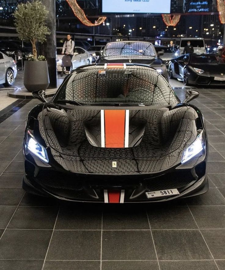 a black and orange sports car on display in a showroom