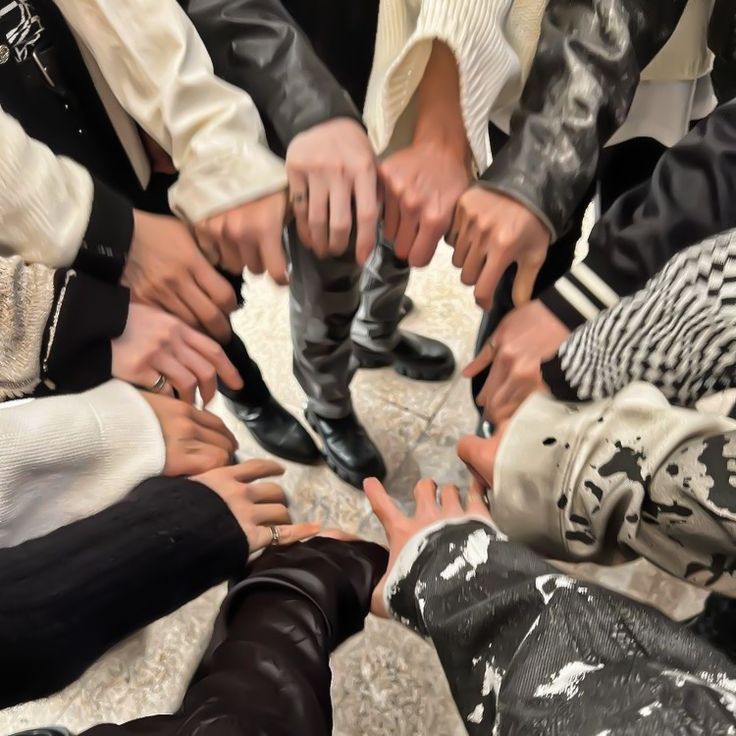 a group of people standing in a circle with their hands on top of each other