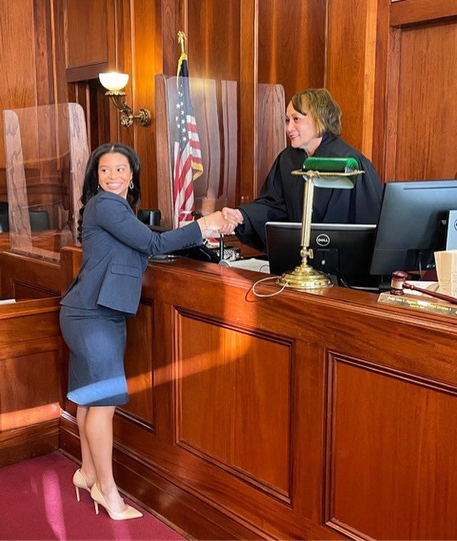 a woman shaking hands with a judge in the courtroom