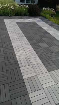 a black and white checkered floor in front of a house with flowers on the side