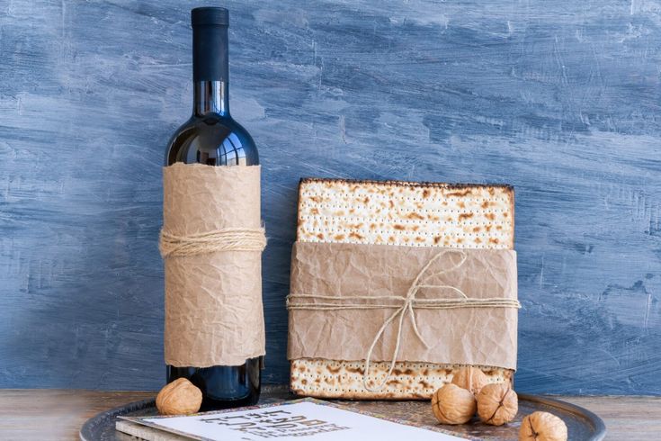 a bottle of wine, crackers and a cork on a plate next to it