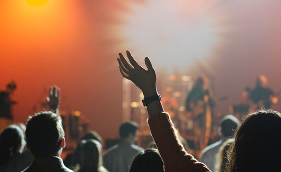 a group of people standing on top of a stage with their hands in the air