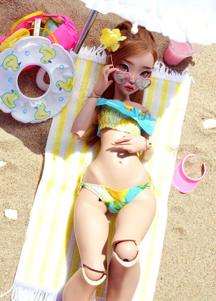 a doll laying on top of a beach towel