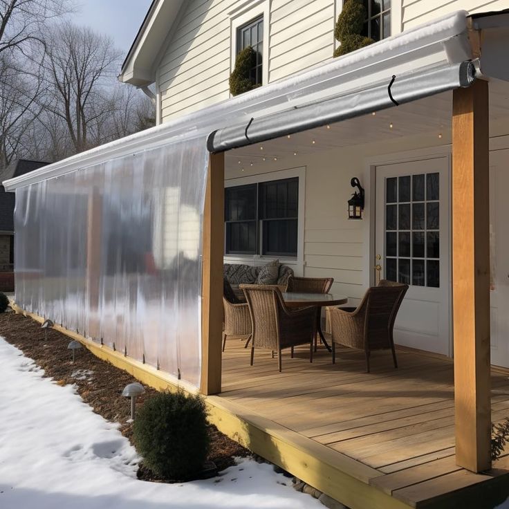 a house with a covered patio and table outside in the snow on a sunny day