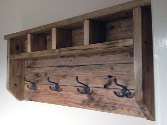 a wooden shelf with hooks on it