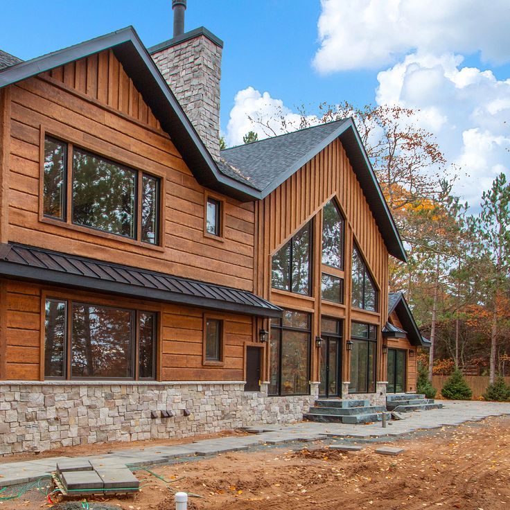 a large wooden house sitting on top of a dirt field