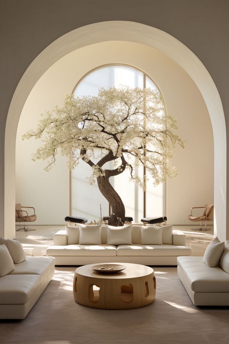 a living room with white couches and a large tree in the middle of it