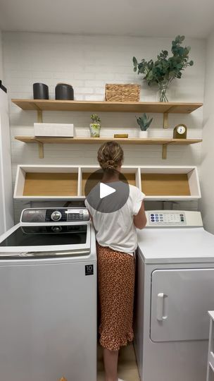 a woman standing in front of a washer and dryer