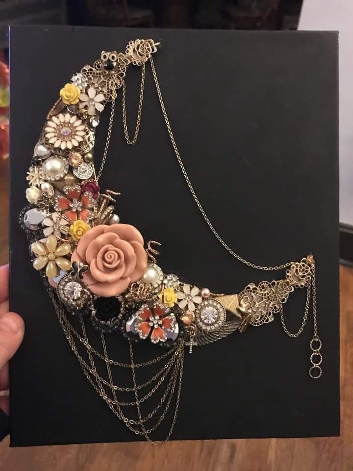 a hand holding up a card with flowers and chains attached to the back of it