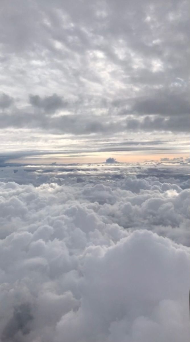 an airplane is flying high above the clouds