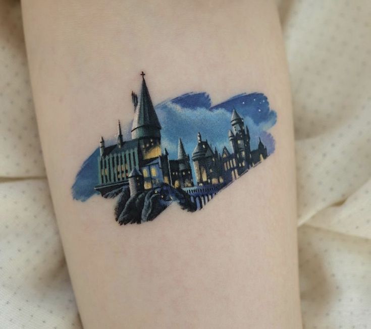 a hogwarts castle tattoo on the right thigh