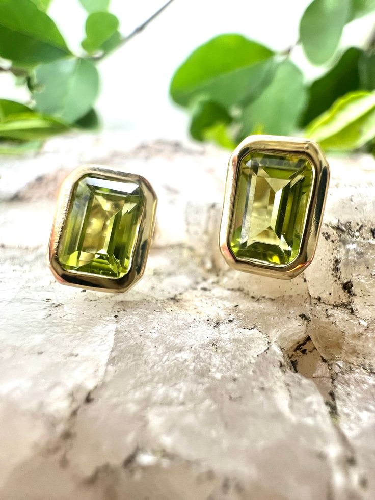 These stunning Peridot Stud Earrings are expertly crafted with genuine peridot stones set in 14kt yellow gold bezel settings for a classic, timeless look. Perfect for adding a vibrant pop of color to any outfit, these earrings will be a beautiful addition to your jewelry collection. These Earrings feature:-1.40 carat Peridot-Bezel Setting-14KT Yellow Gold Style #210-00180 Necklace not included Formal Green Earrings With Bezel Setting, Green Bezel Set Earrings For Formal Occasions, Classic Green Earrings With Bezel Setting, Green 14k Gold Earrings With Bezel Setting, Classic Green Peridot Earrings, Green Earrings With Bezel Setting For May Birthstone, Lime Green Peridot Gemstone Earrings, Yellow Gold Bezel Setting Earrings For May Birthstone, Peridot Stone