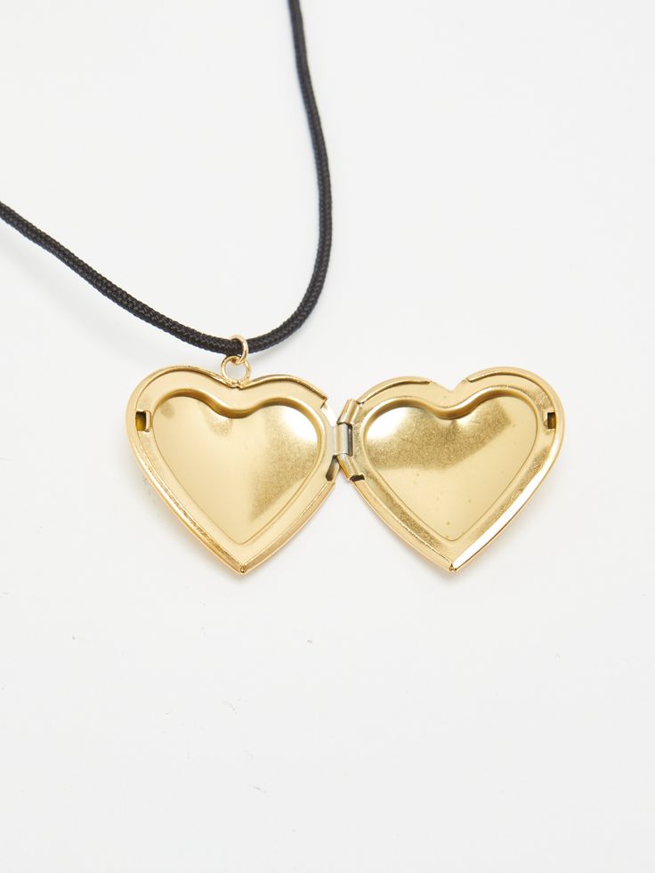 The Heart Locket Necklace is handmade in Los Angeles and knotted with nylon string for extra adjustability. The classic locket shape originally featured as our Heart Locket Earrings have been reshaped and repurposed to create a new design. Material: Stainless Steel Gold Plated / Black Nylon Cord / Hand knotted Care: Pull on strings lightly to adjust. Remove when showering. Wear and tear will occur on cords over time. Dimensions: 27" Total length. Adjustable to necklace or choker. Weight: .2 oz M Adjustable Locket Pendant Necklace, Adjustable Heart Pendant Locket Necklace, Adjustable Heart Charm Necklace With Round Pendant, Heart Shaped Jewelry With Adjustable Cord As Gift, Adjustable Pendant Locket Necklace, Adjustable Open Heart Necklace With Adjustable Chain, Adjustable Heart Pendant Necklace With Locket, Adjustable Heart Pendant Jewelry As A Keepsake, Adjustable Heart Charm Locket Necklace Gift