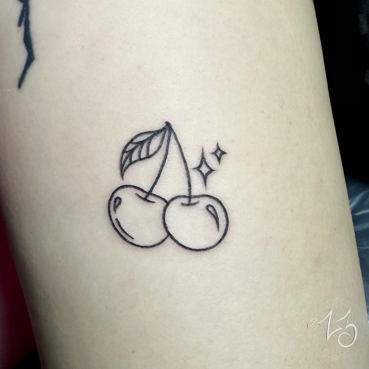 a small tattoo of two cherries on the thigh