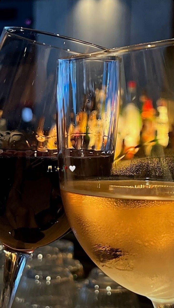 two glasses of wine sitting on top of a table