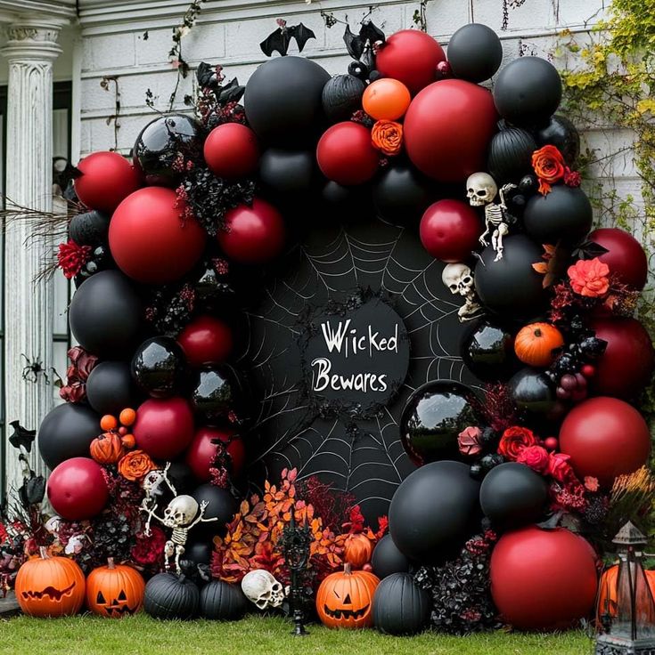 a decorated halloween wreath in front of a house with pumpkins and skulls on it