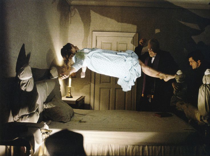 a woman is falling off her bed while others look on