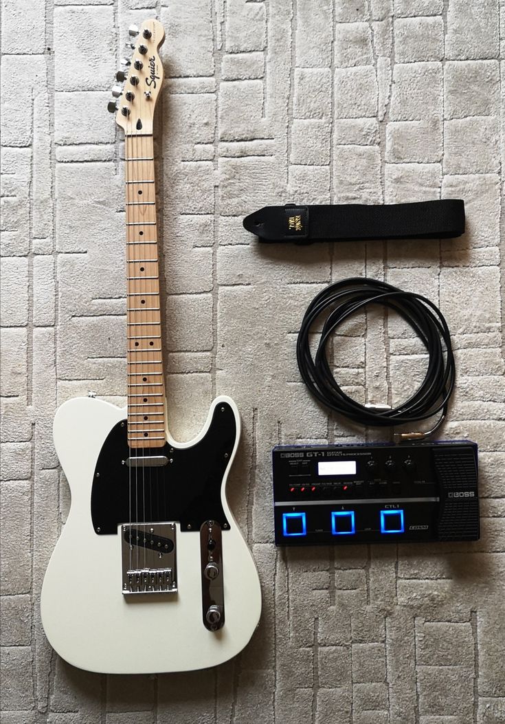 an electric guitar and other accessories laid out on the floor