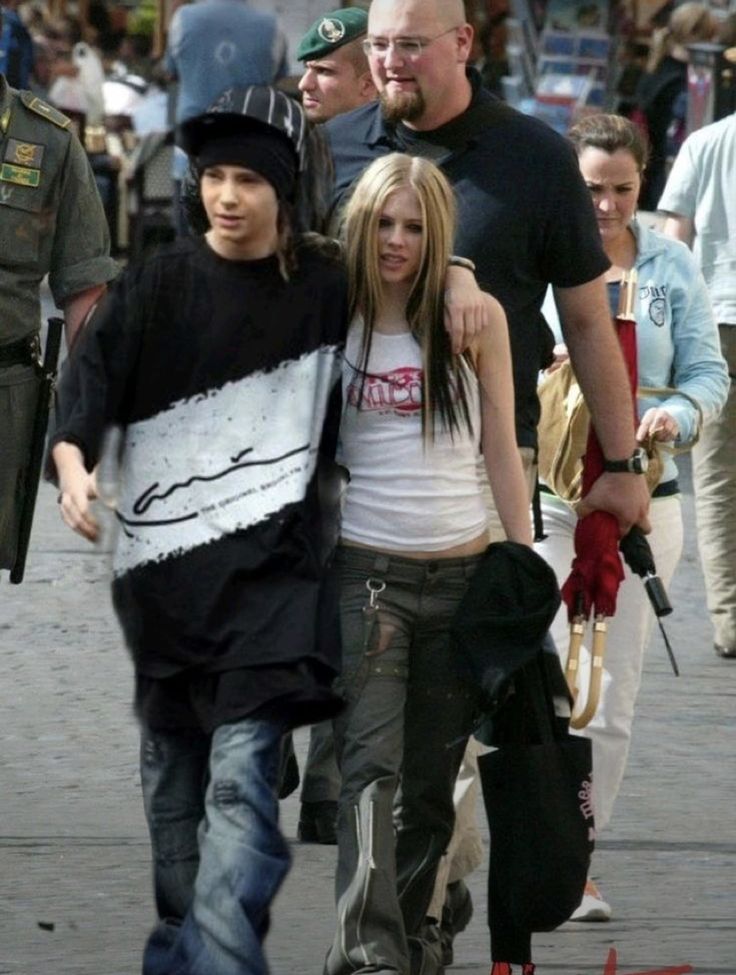 three people walking down the street with police in the background