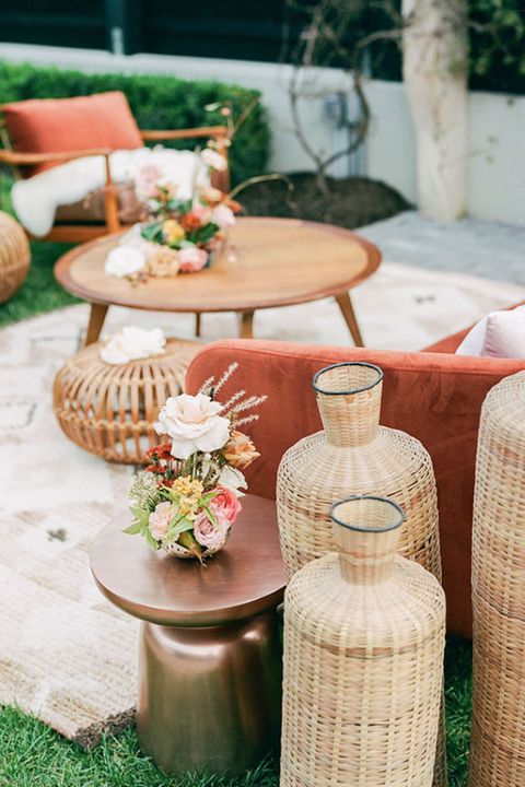 wicker furniture and vases are arranged on the grass