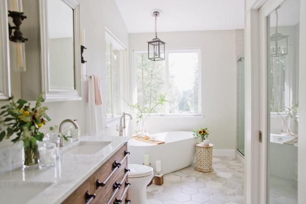 a bathroom with a tub, sink and mirror