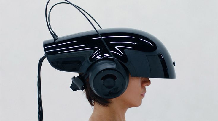 a woman wearing a virtual reality headset in front of a white wall with wires running through it