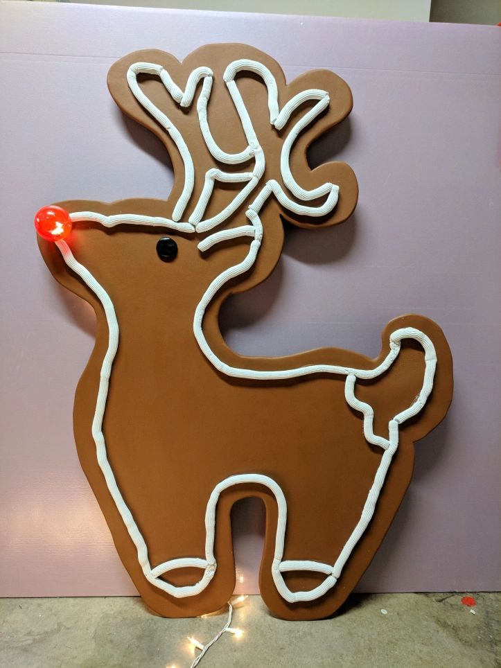 a cookie shaped like a deer with red lights on its antlers