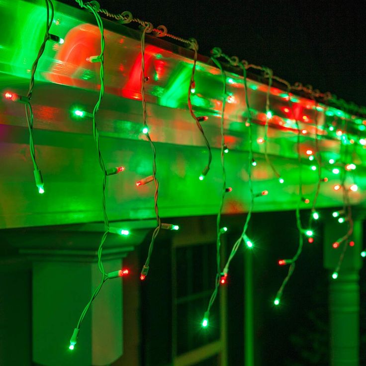 green and red lights are hanging from the side of a building