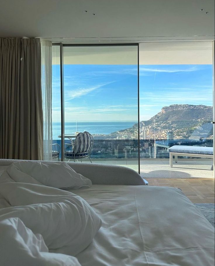 a bedroom with a large window overlooking the ocean