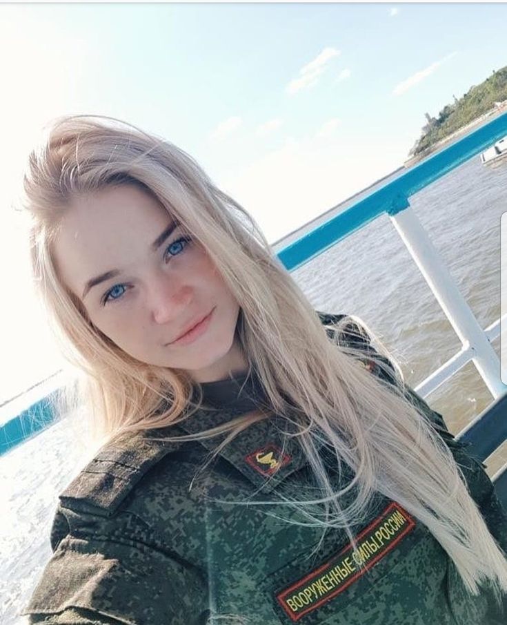 a woman with blonde hair and blue eyes is posing for a photo on a boat