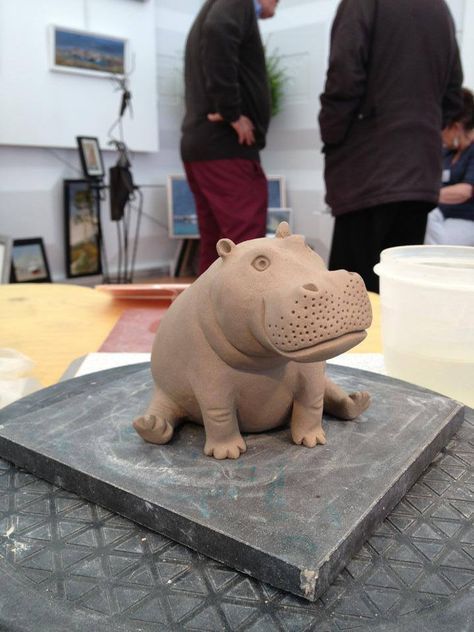 a sculpture of a hippopotamus sitting on top of a table