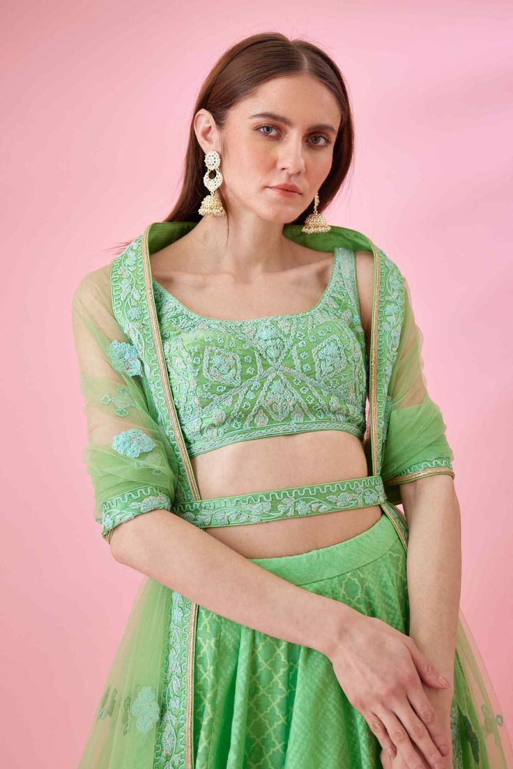 Editor's Note This is a beautiful and unique lehenga set that features patchwork and thread embroidery. The lehenga is made of chanderi jacquard fabric and has a matching belt to cinch in the waist. The blouse is also embroidered to match the lehenga, and the set comes with a coordinating dupatta. Color: Green Fabric: Modal satin & chanderi jacquard Embroidery details: Thread embroidery Components: Lehenga, dupatta, belt & blouse Occasion: Haldi mehndi, festive and wedding guest Disclaimer: Prod Festive Reception Sets With Chikankari Embroidery, Green Chanderi Choli With Intricate Embroidery, Party Sets With Chikankari Embroidery On Raw Silk, Designer Lehenga In Dola Silk With Chikankari Embroidery, Floor-length Chikankari Embroidery Silk Sets, Eid Choli With Chikankari Embroidery On Organza, Eid Lehenga With Chikankari Embroidery In Raw Silk, Pista Green Choli With Intricate Embroidery For Festive Occasions, Navratri Chanderi Sets With Intricate Embroidery