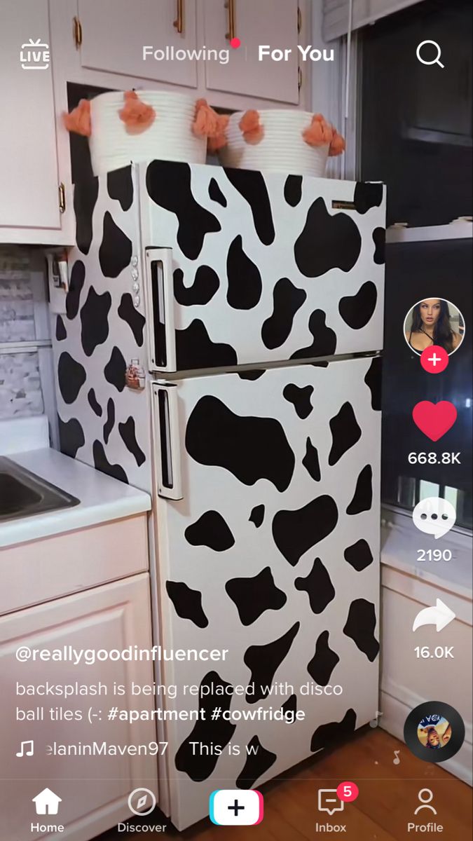 a refrigerator covered in black and white cow prints