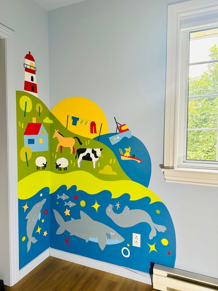 a child's room decorated in blue, yellow and green with an ocean scene painted on the wall