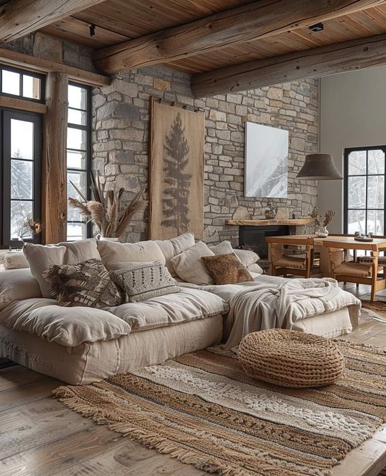 a living room filled with lots of furniture next to large windows on top of a wooden floor