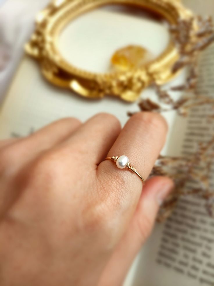 ✨ Tiny Freshwater Pearl Ring with choices of 14K Gold Filled, Rose Gold Filled or 925 Sterling Silver, June Birthstone Gift 💙 Dainty stacking ring with one small pearl. Make a very cute pinky ring. *Pearl Size: 4 mm *Ring Band: 0.8 mm ✨ Pearl symbolizes modesty, innocence & purity. Pearl is believed to offer protection, as well as attract good luck & wealth ✨ * Handmade in your ring size with 14K gold-filled or Sterling Silver wire and Natural Freshwater Pearl. * 14K gold-filled wire is known f Delicate Tiny Jewelry For Anniversary, Elegant 14k Gold Filled Promise Ring, Rose Gold Pearl Ring Gemstone Gift, Rose Gold Gemstone Pearl Ring Gift, Rose Gold Pearl Ring With Gemstone For Gift, 14k Gold Filled Open Rings For Wedding, Elegant 14k Gold-filled Rose Gold Stackable Rings, Rose Gold 14k Gold Filled Midi Rings For Wedding, 14k Gold Filled Wedding Ring