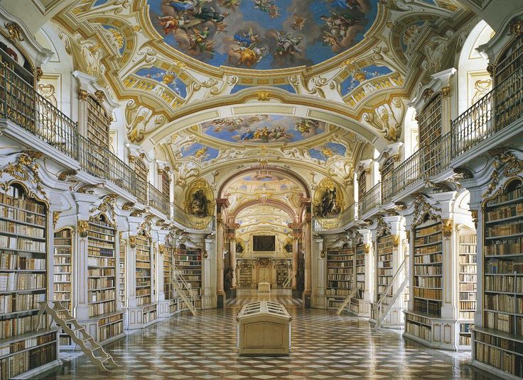 the interior of a large library with many bookshelves and paintings on the ceiling